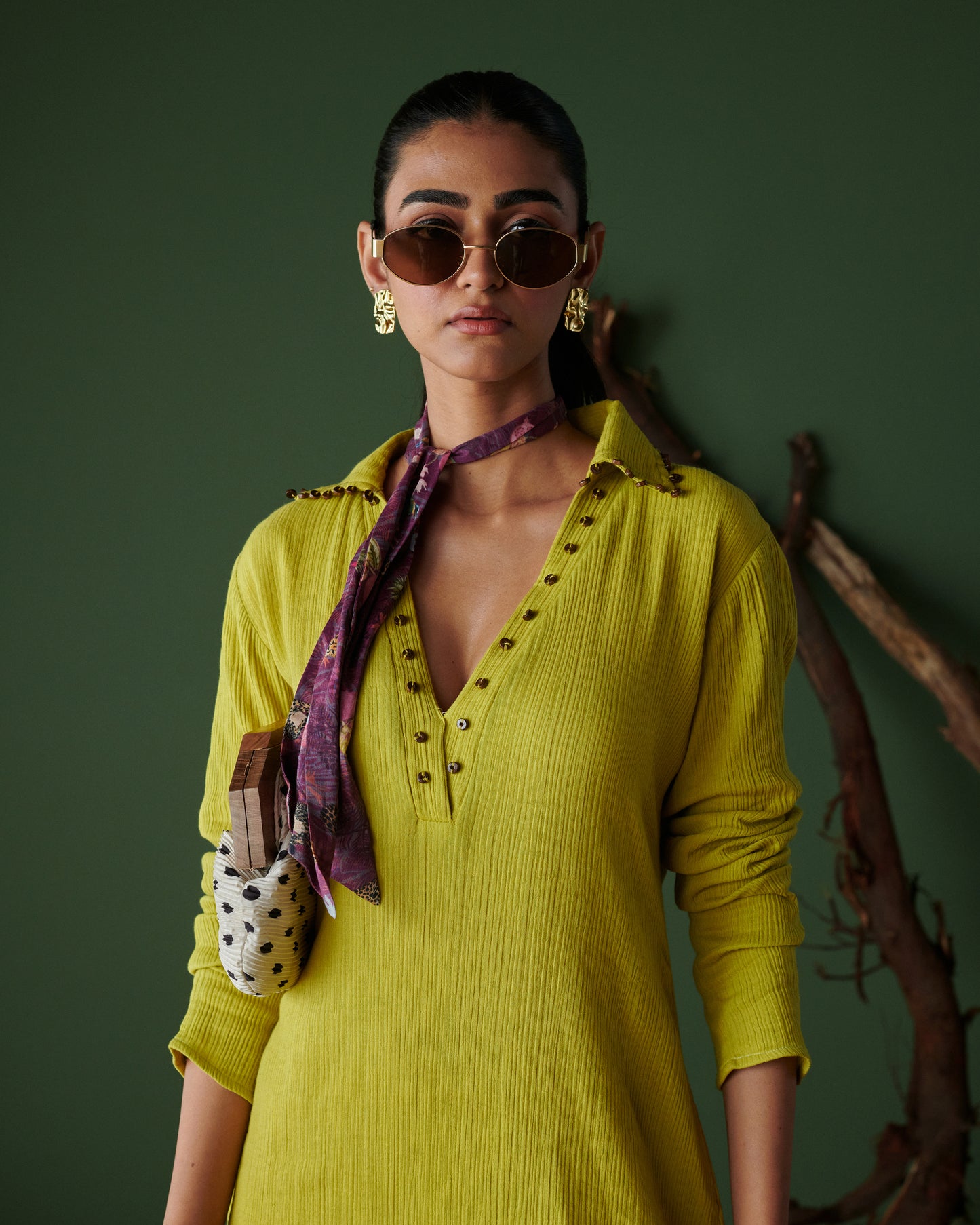 Close-up of model in Aam Panna mango yellow midi dress by Naarangi, styled with scarf, sunglasses and statement earrings.