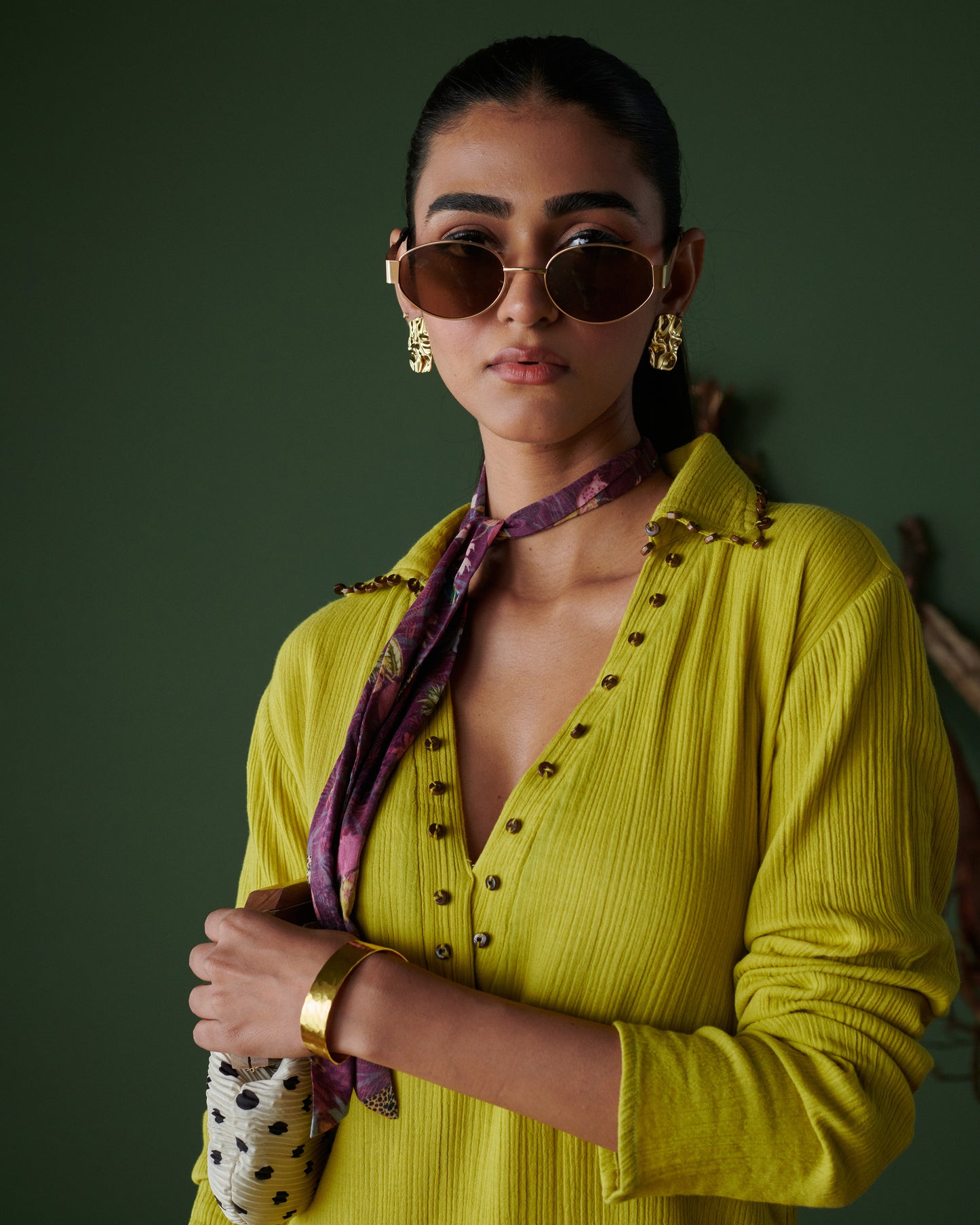 Dramatic close-up of model in Aam Panna mango yellow midi dress by Naarangi, styled with scarf, sunglasses and gold jewelry.