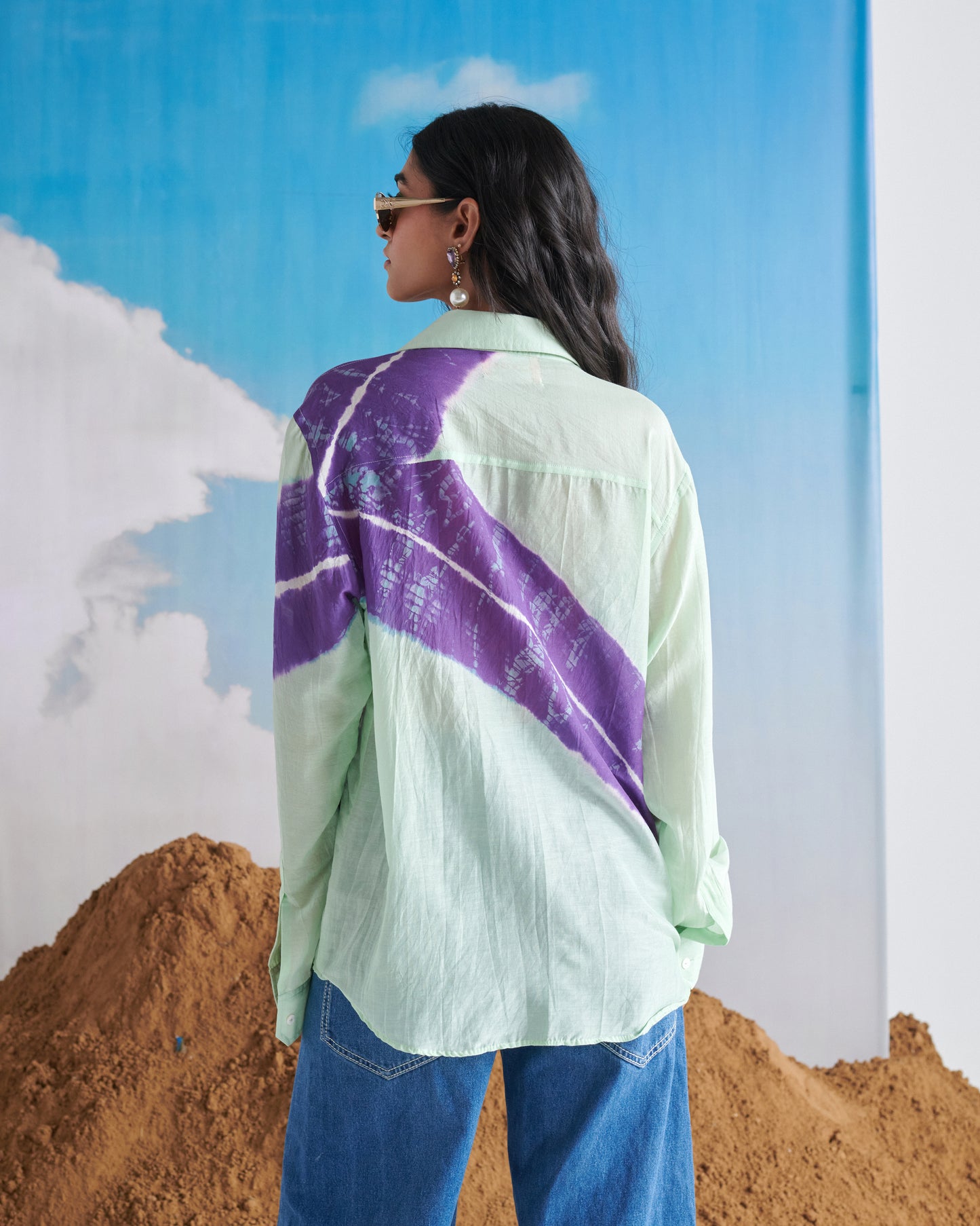 Back pose of model wearing Naarangi Aasmani Leher shirt in soft blue wave print.
