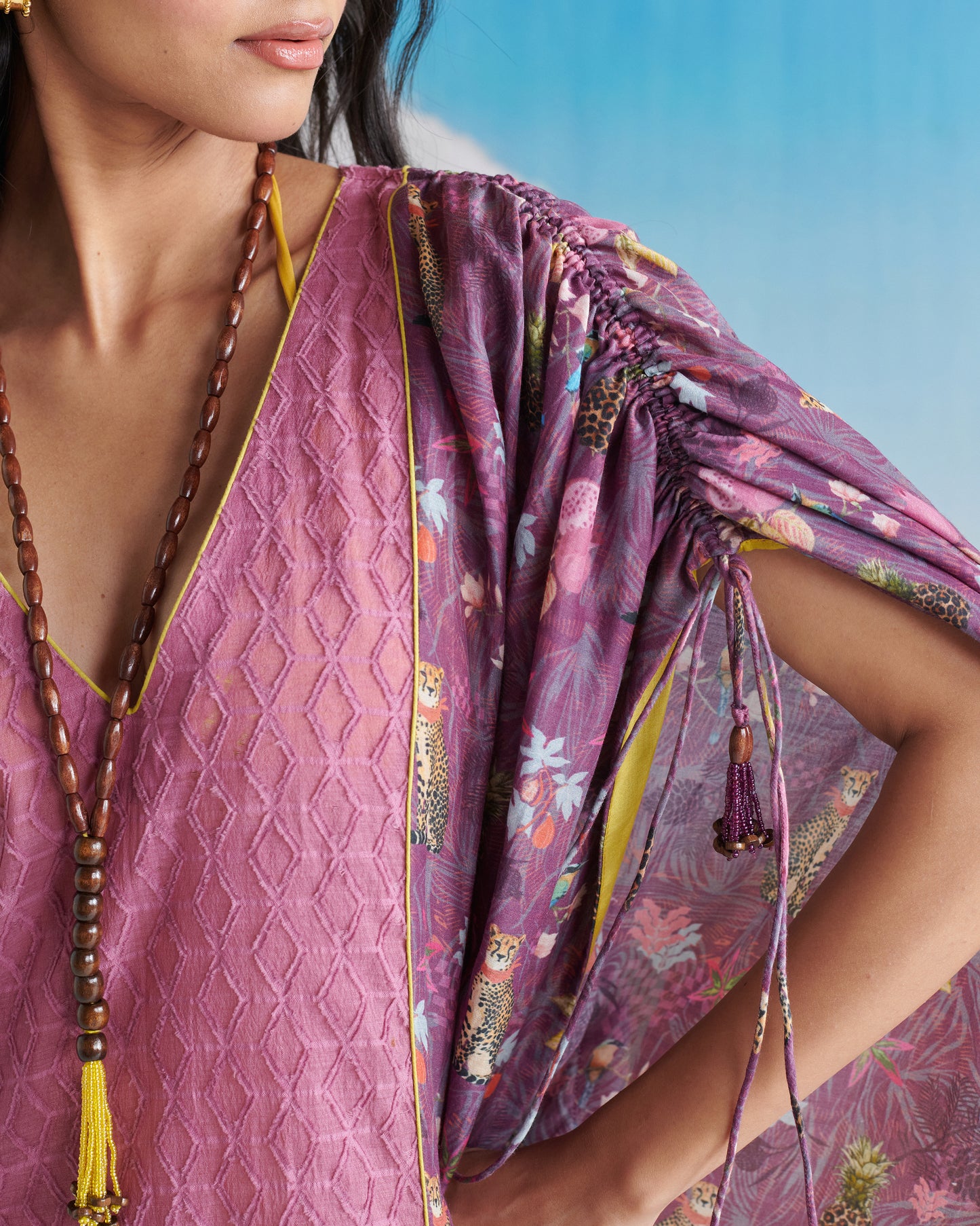 Closeup of Naarangi Falsa Fantasy kaftaan showing detailed fabric and purple shades.