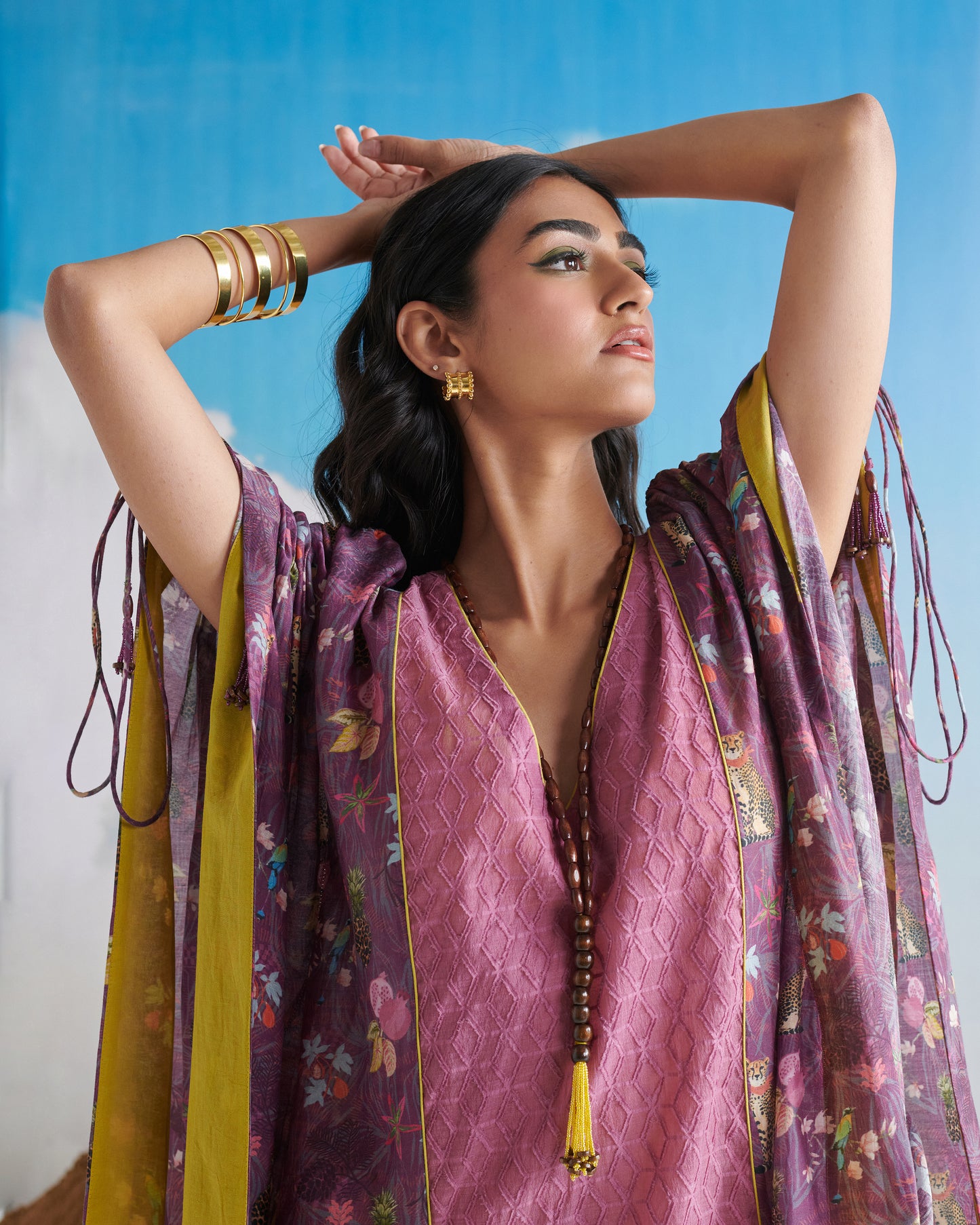 Side profile of woman in Naarangi Falsa Fantasy kaftaan, elegant purple flowy outfit.