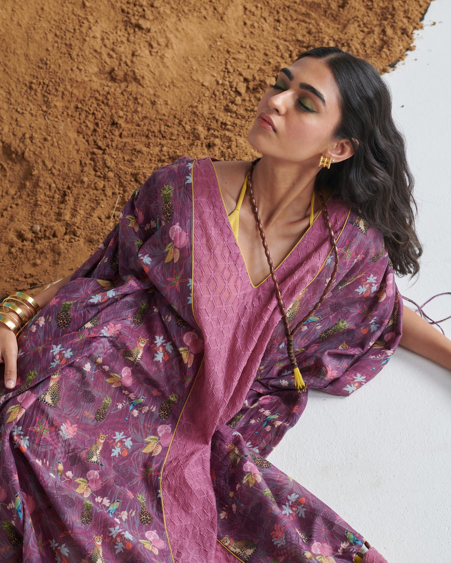 Stylish model posing in Naarangi Falsa Fantasy kaftaan, purple shaded flowing attire.