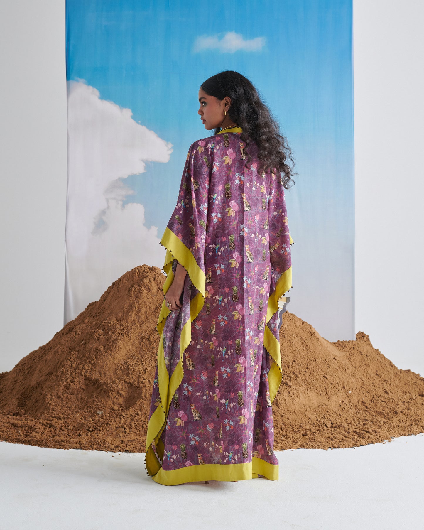 Back view of model wearing Plum Passion kaftaan with lime border and all-over plum print.