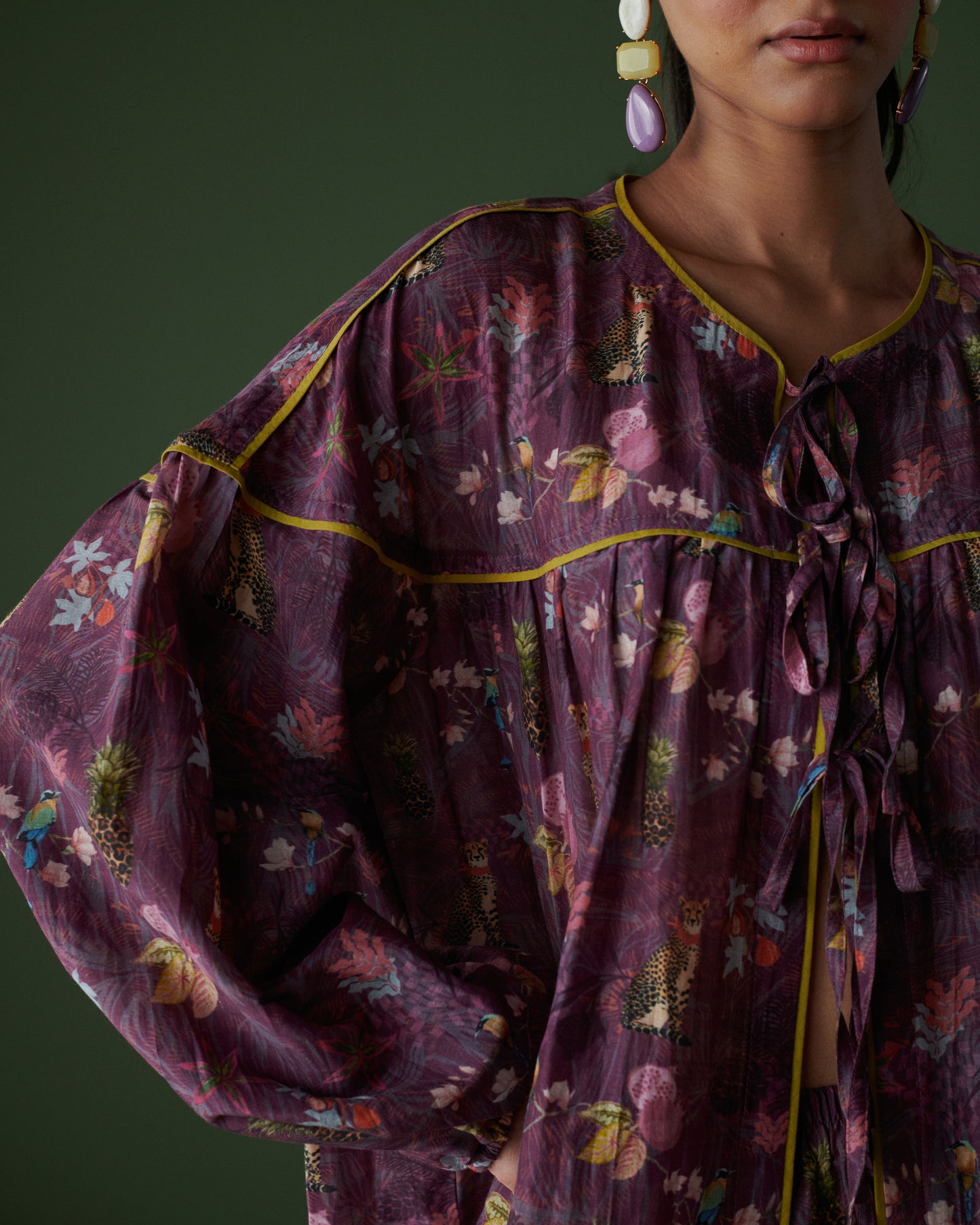 Detailed view of Tropical Ras purple floral top highlighting sleeve design and fabric texture.