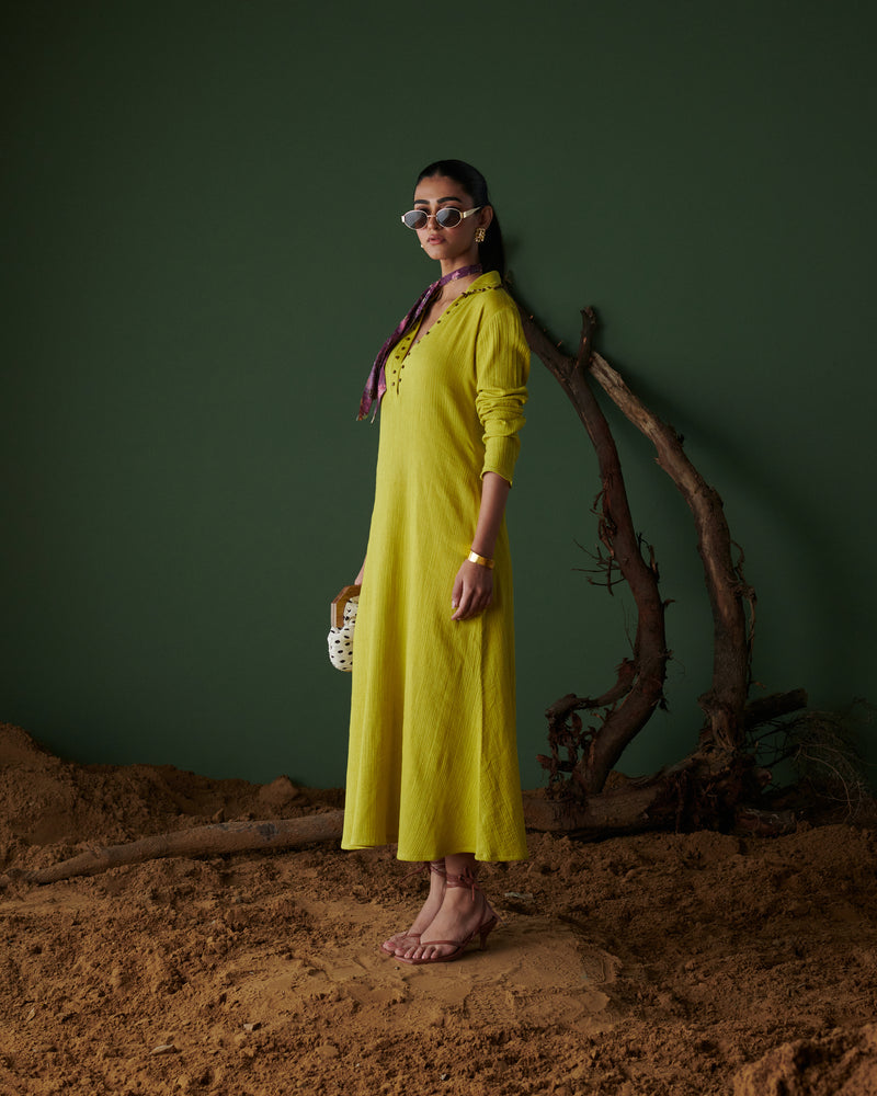 Side profile of model in Aam Panna mango yellow midi dress by Naarangi, styled with scarf, sunglasses and statement jewelry.