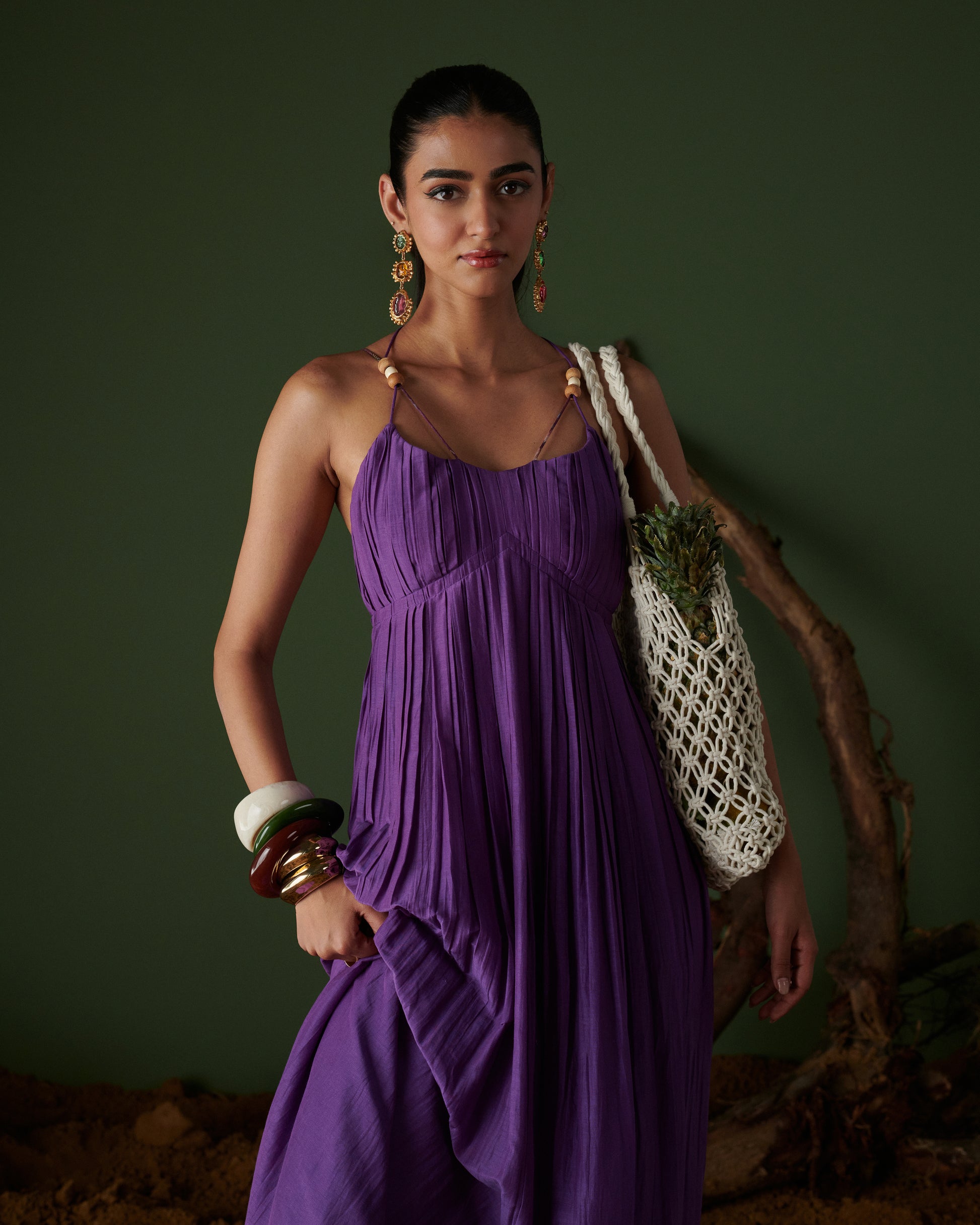 Jamun Jalsa purple maxi dress with pleated detail, bead straps and flowy silhouette styled with chic tote by Naarangi.