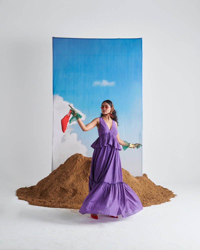 Model wearing KalaKhatta Crush Dress in deep purple, stylish sleeveless flared maxi gown with layered design for women.