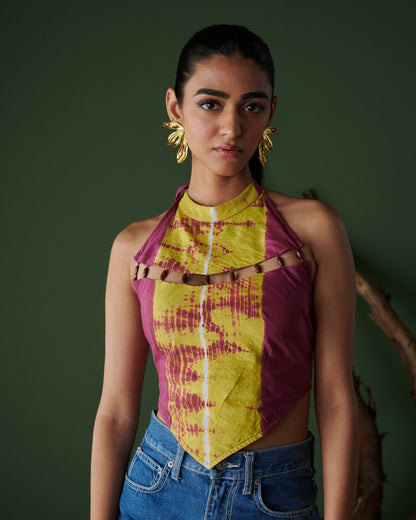 Close-up front view of Meetha Jaljeera Top in wine and deep yellow by Naarangi, a vibrant women’s halter-neck top with cut-out accents, hand-dyed using traditional techniques, styled with blue denim jeans, blending ethnic craftsmanship with modern boho-chic fashion in India.
