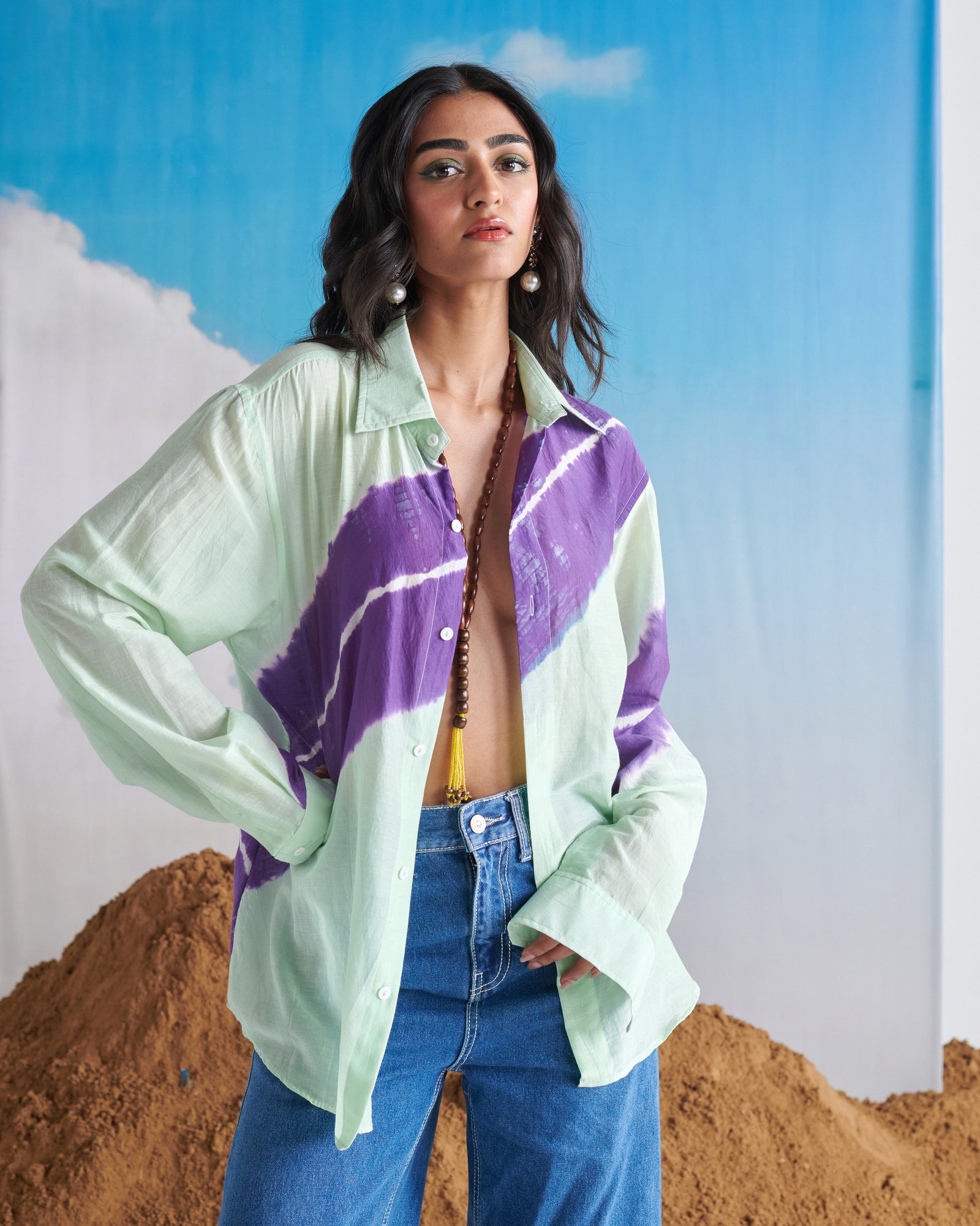 Side profile of model in Naarangi Aasmani Leher blue shirt with leheriya design.