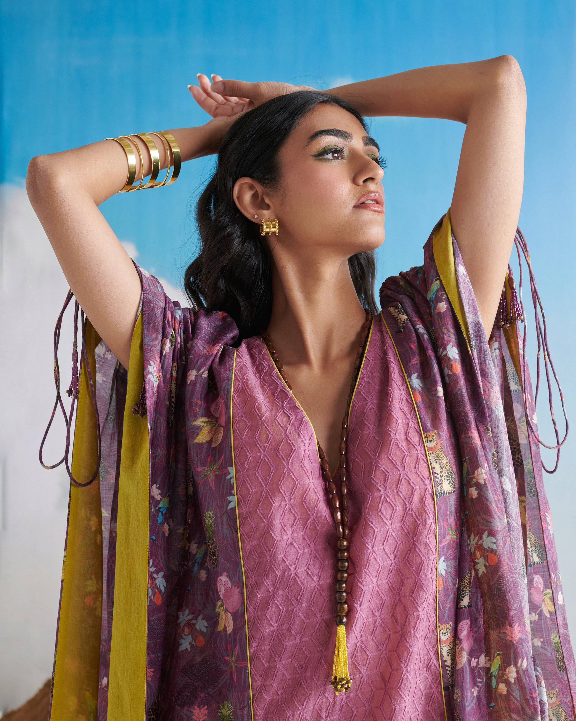 Side profile of woman in Naarangi Falsa Fantasy kaftaan, elegant purple flowy outfit.