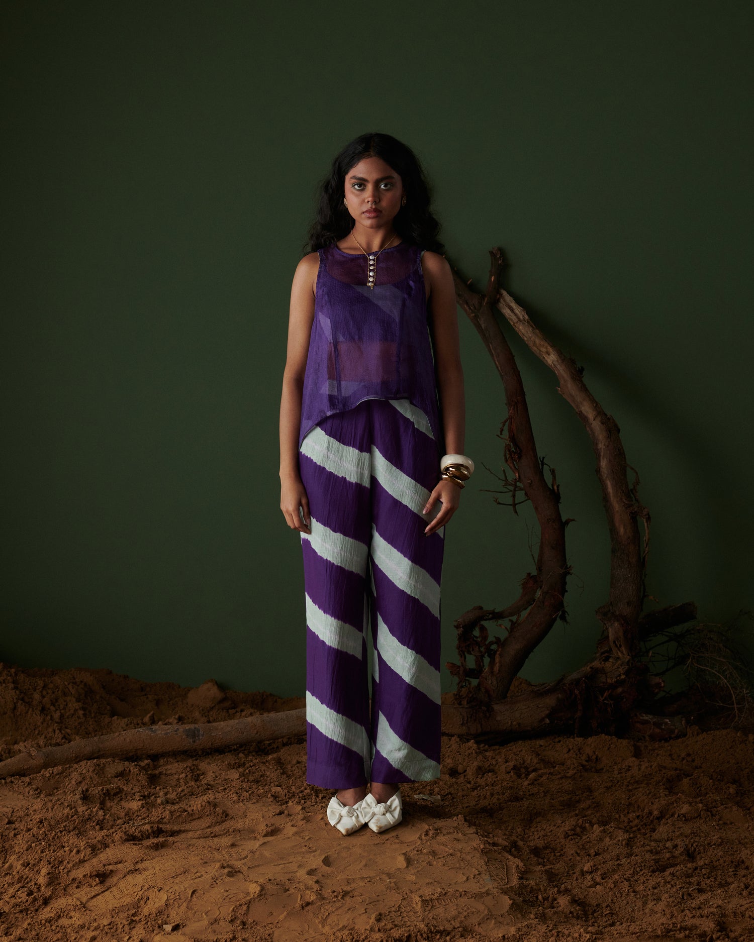 Naarangi Jamun Swirl Pants in purple with bold white swirl stripes, wide-leg fit styled with sleeveless sheer purple top.