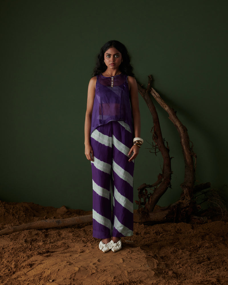 Naarangi Jamun Swirl Pants in purple with bold white swirl stripes, wide-leg fit styled with sleeveless sheer purple top.
