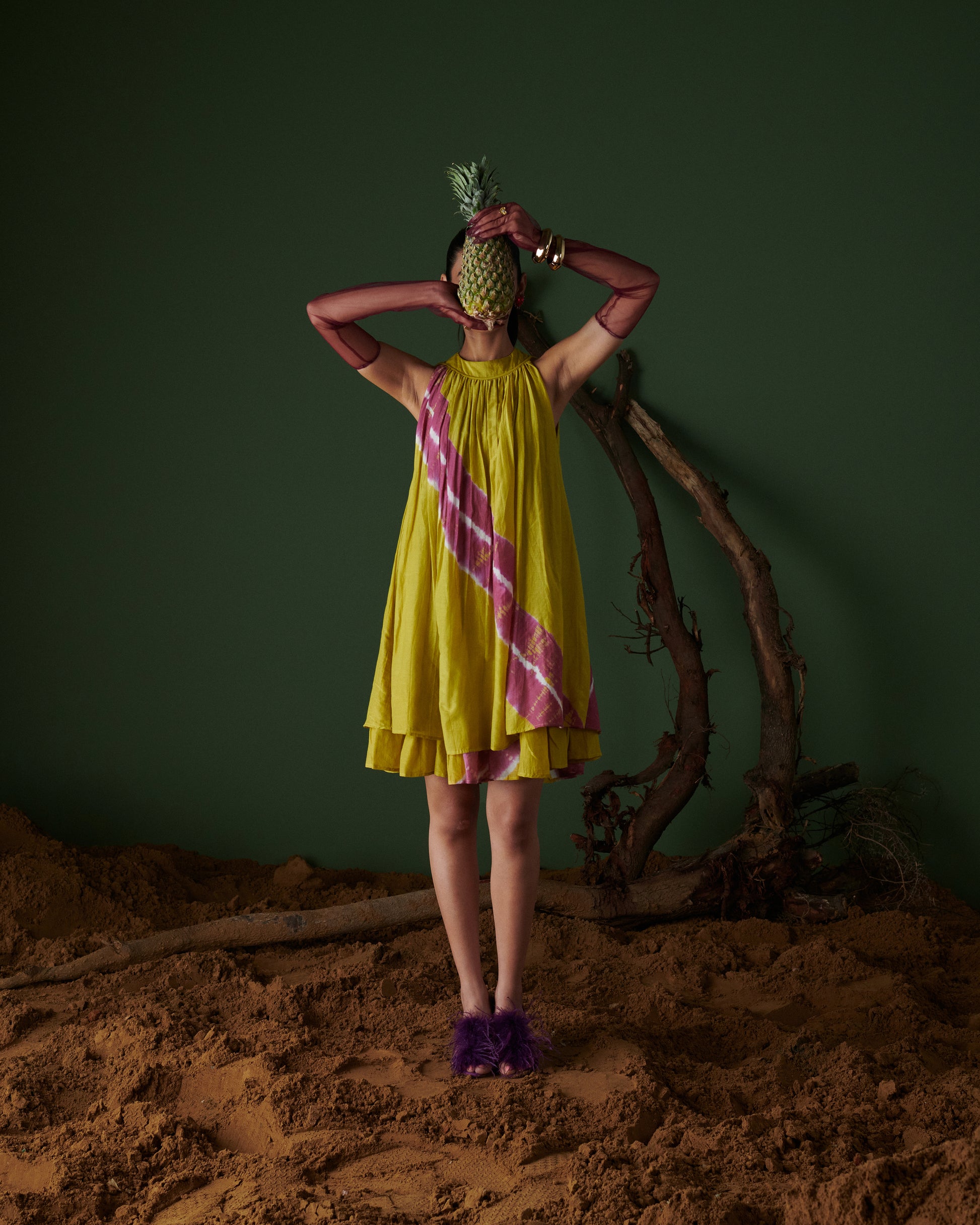 Full front view of model wearing Naarangi Nimbu Twist yellow dress with pink pattern.