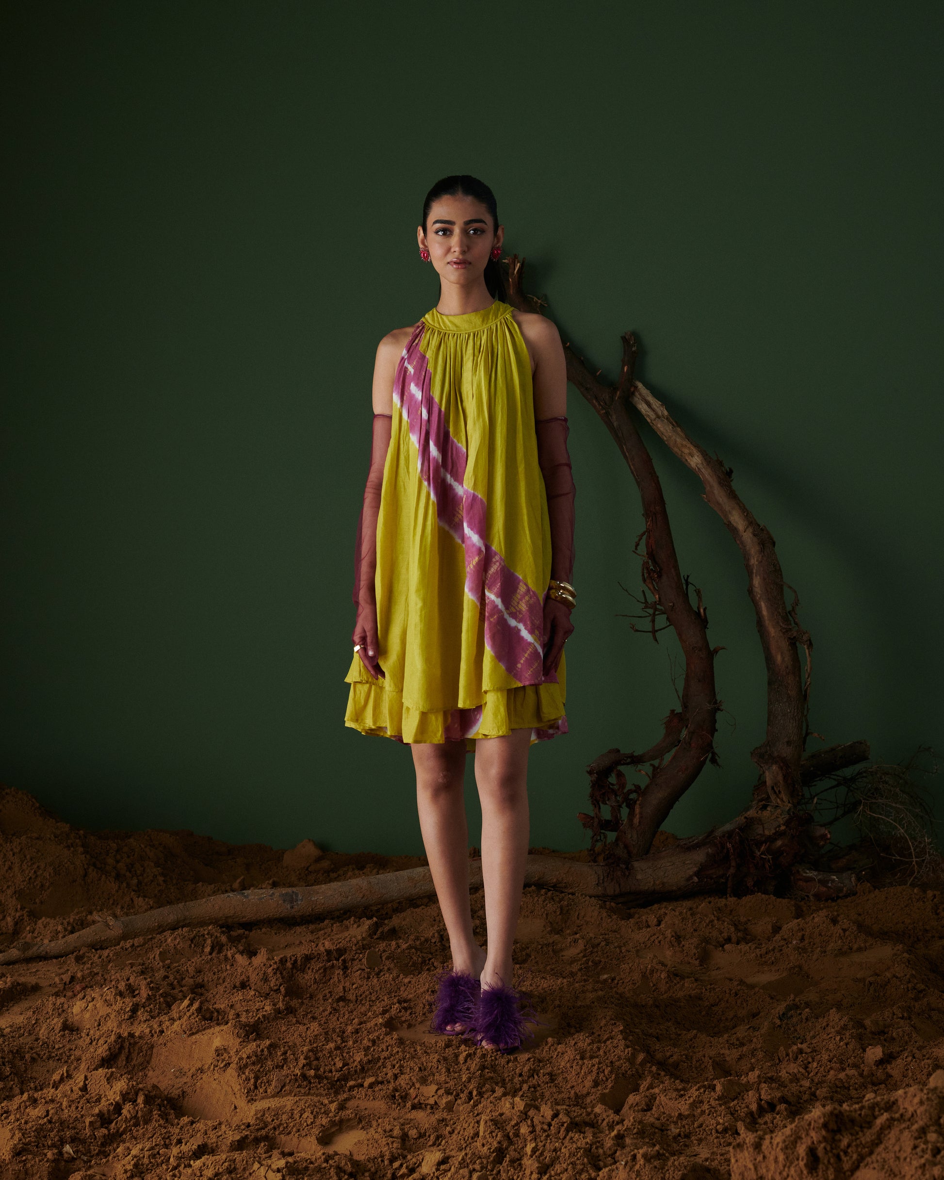 Woman posing in Naarangi Nimbu Twist dress, bright yellow with pink diagonal design.