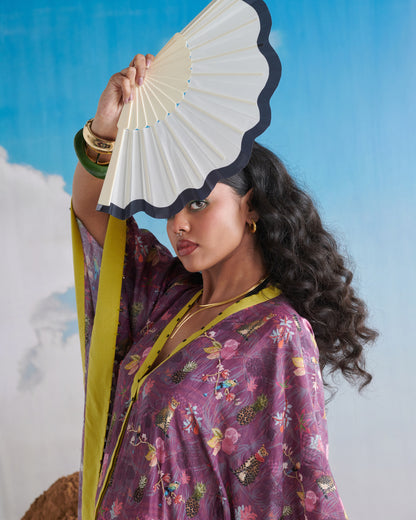 Portrait close-up with fan; Plum Passion kaftaan showing lime neckline and print.