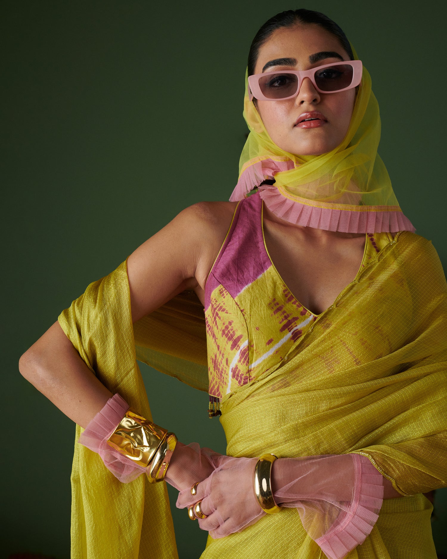 Close-up of model in Nimbu Soda Pop saree with blouse by Naarangi, lime yellow saree paired with magenta blouse and pink sunglasses, modern Indian ethnic wear.