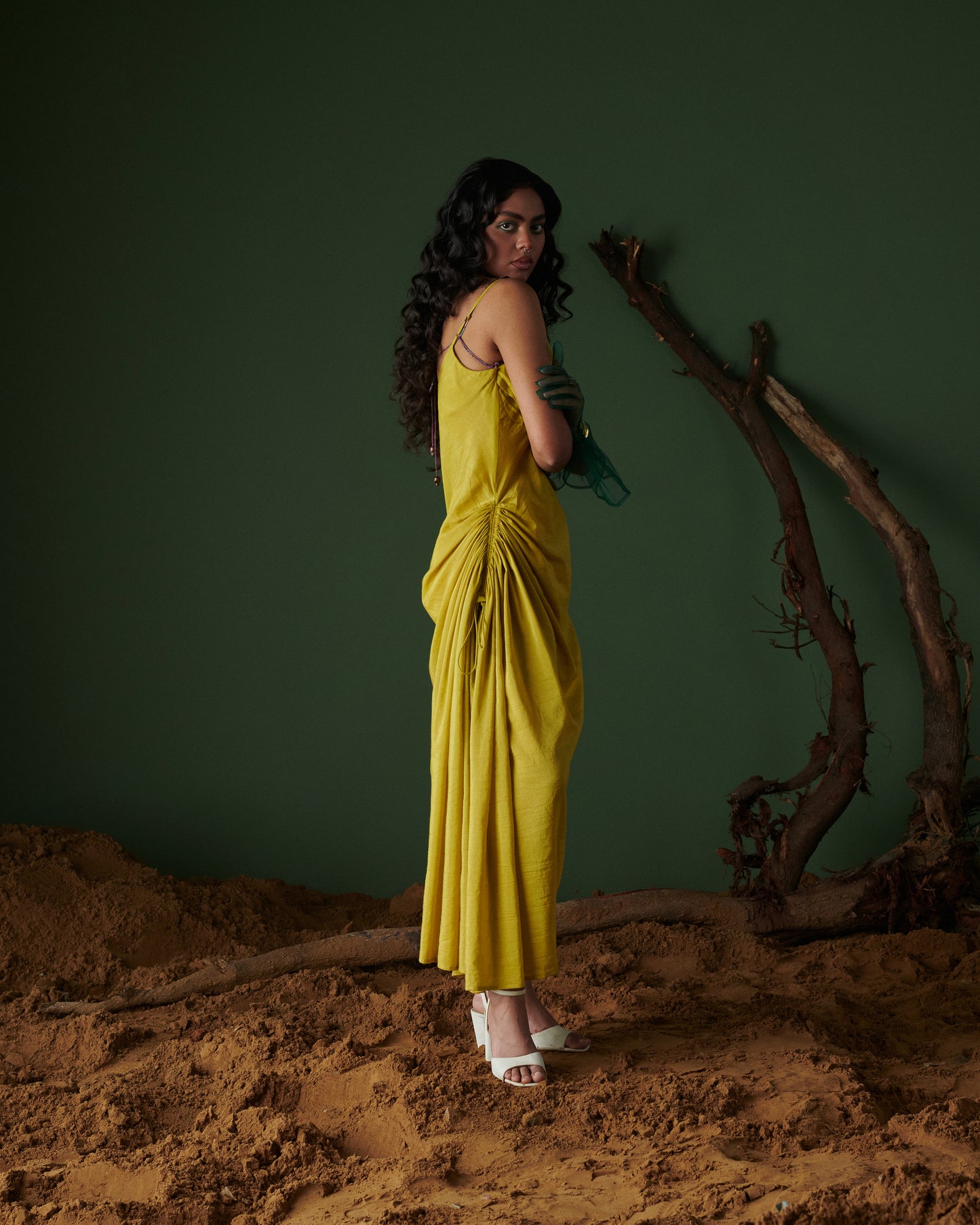 Model in Sunheri Zest Dress, yellow with ruched side drape and back tie-up, styled with white heels by Naarangi.