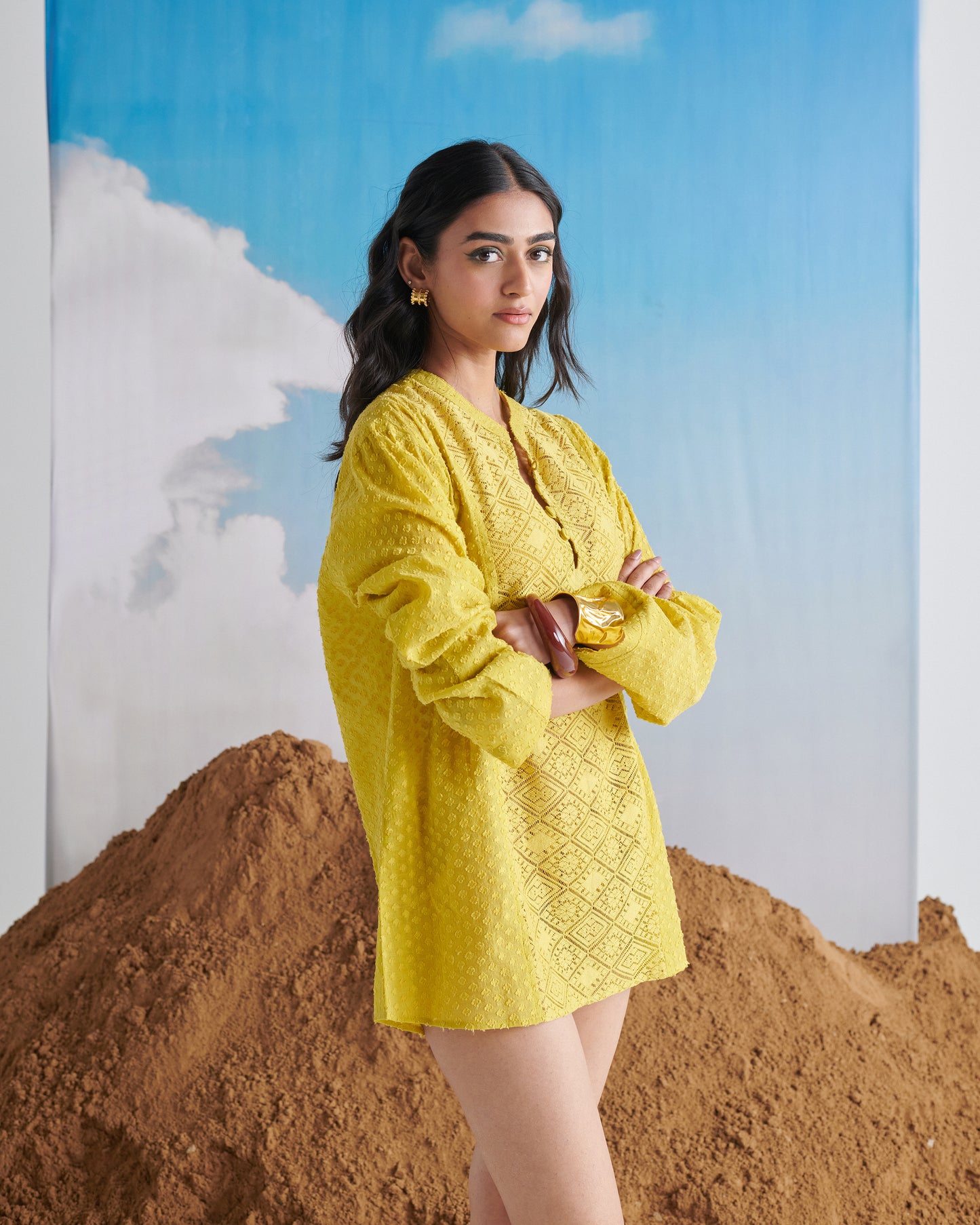 Side pose of Tangy Tadka Kurta in bright yellow, showing textured fabric, long sleeves, button neckline and chic detailing.