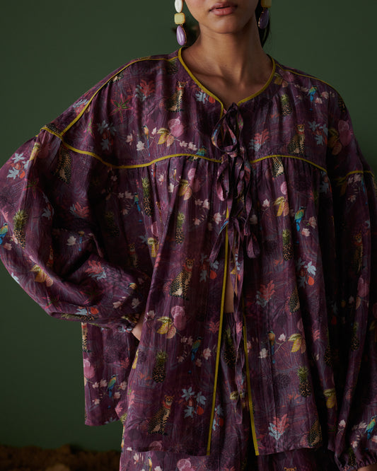 Close-up view of Tropical Ras purple floral top with tie-up neckline and long sleeves.