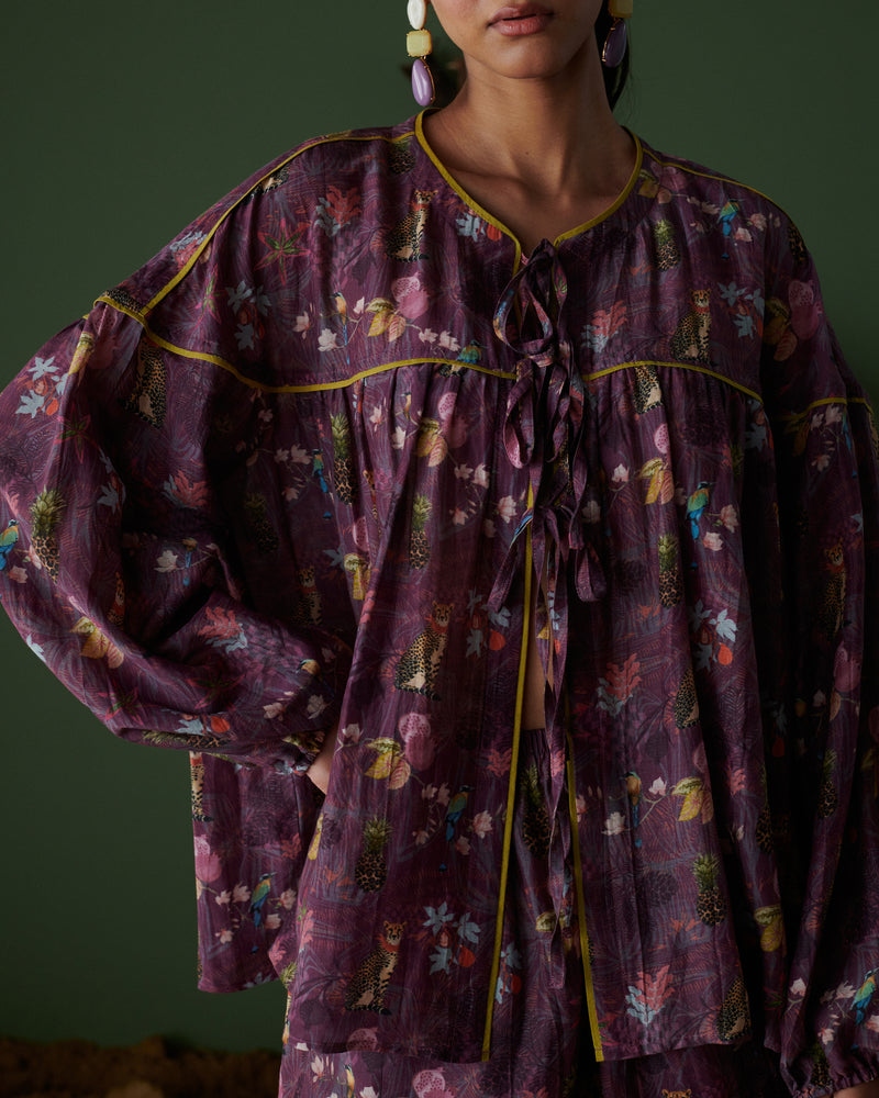 Close-up view of Tropical Ras purple floral top with tie-up neckline and long sleeves.