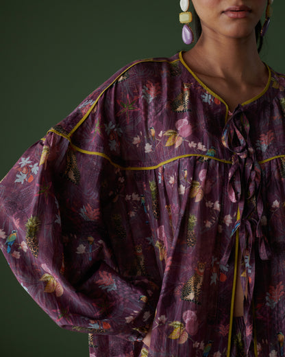Detailed view of Tropical Ras purple floral top highlighting sleeve design and fabric texture.